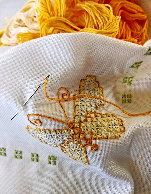 A butterfly motif being stitched in gold thread