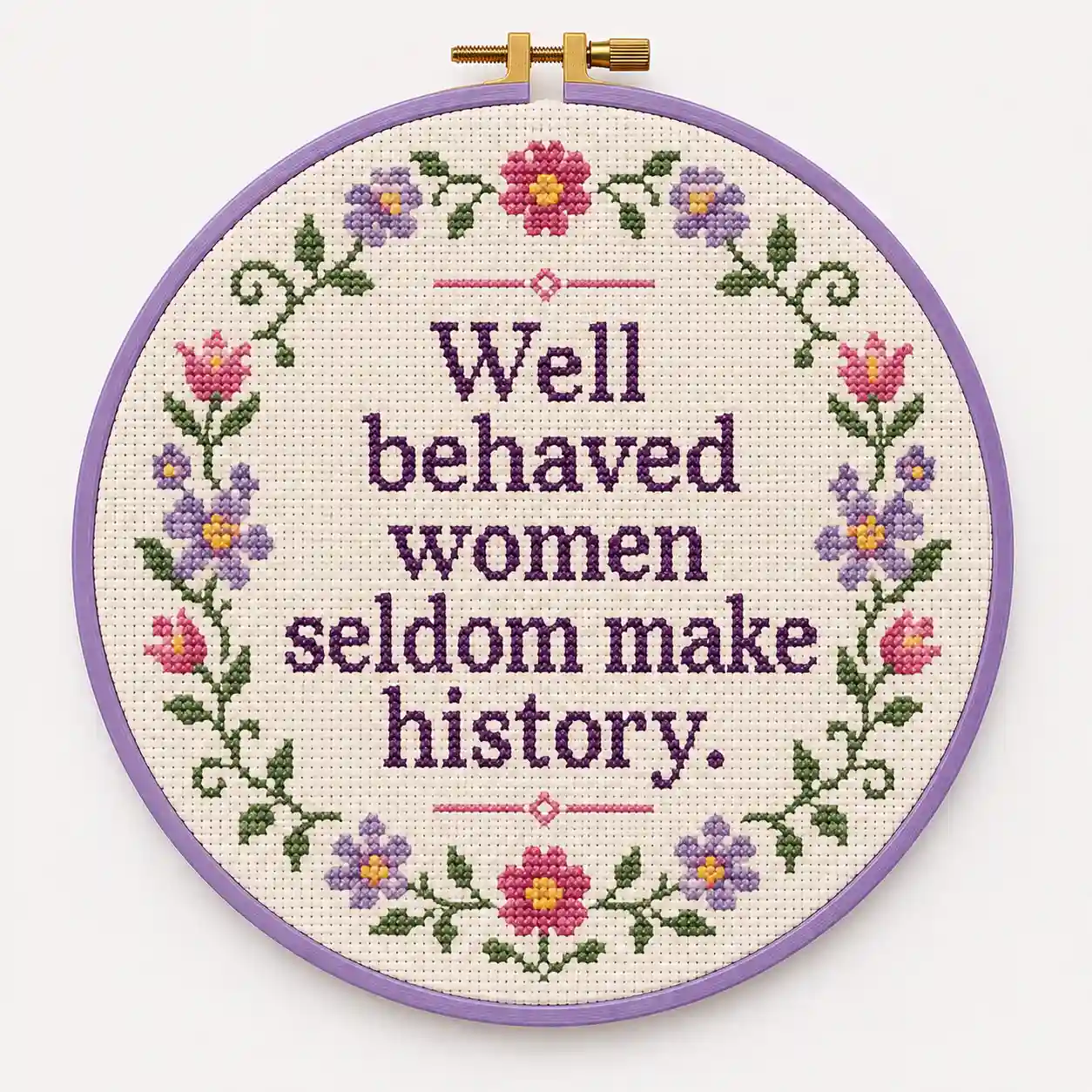 A traditional floral-bordered hoop stitched with the phrase "Well behaved women seldom make history"