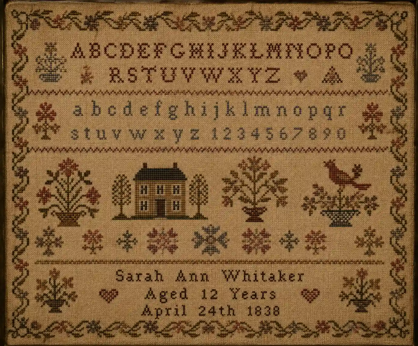 A classic sampler with alphabet, small motifs, a house, a border, and a name-and-date line