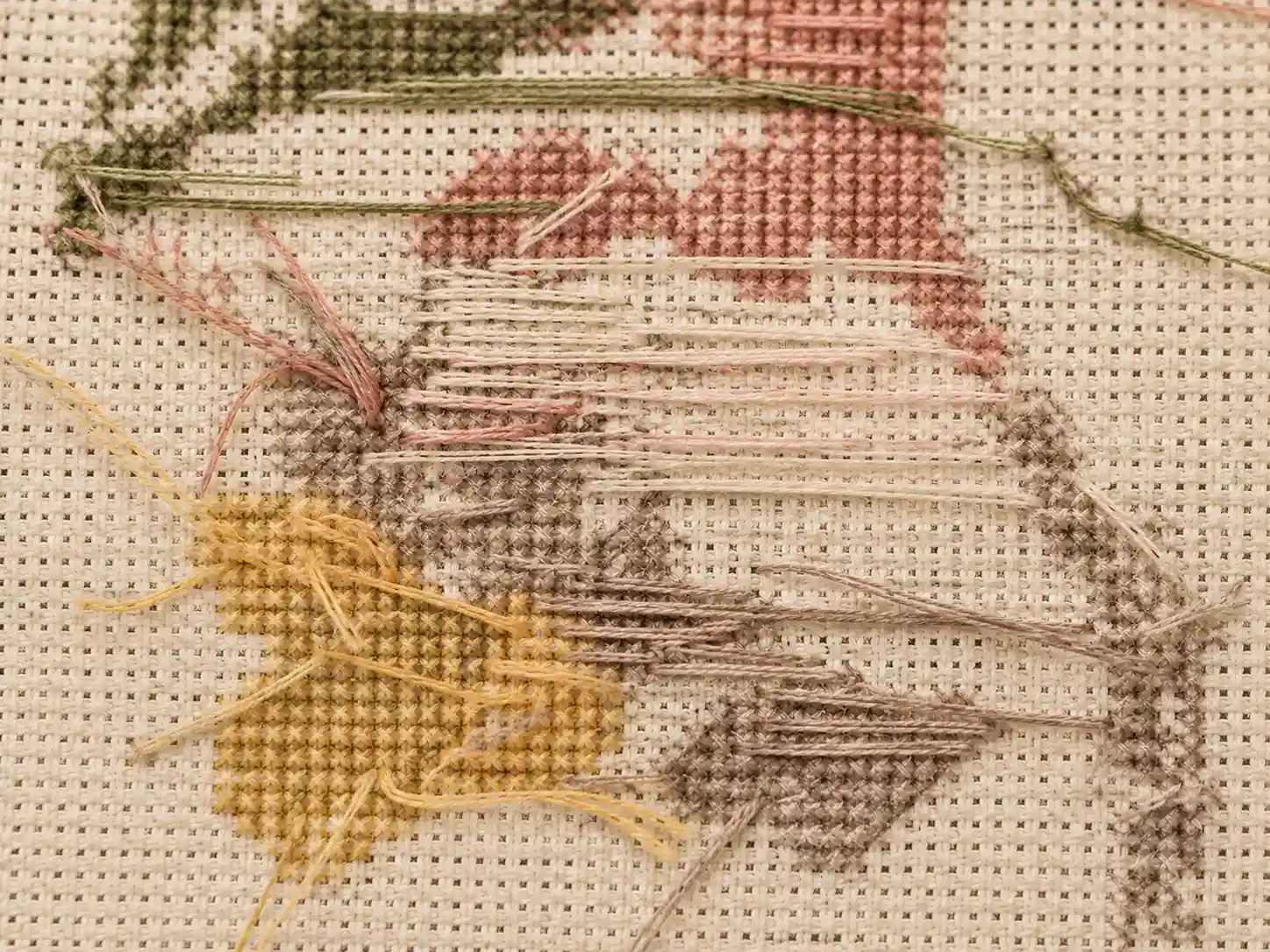 The back of a piece of stitching showing carried and parked thread tails