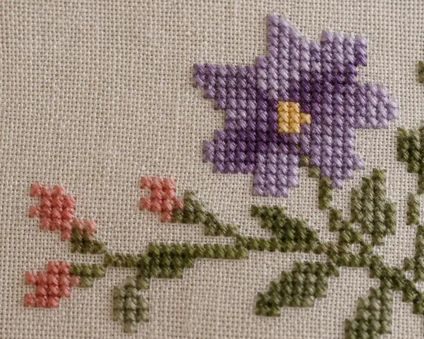 Cross stitch worked on fine linen with individual threads visible rather than Aida's blocky grid